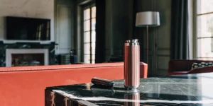 A sleek, metallic banger rig displayed on a black marble surface in a modern living room.