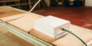 Rows of white HID lamp ballasts neatly arranged on shelves in an industrial setting.